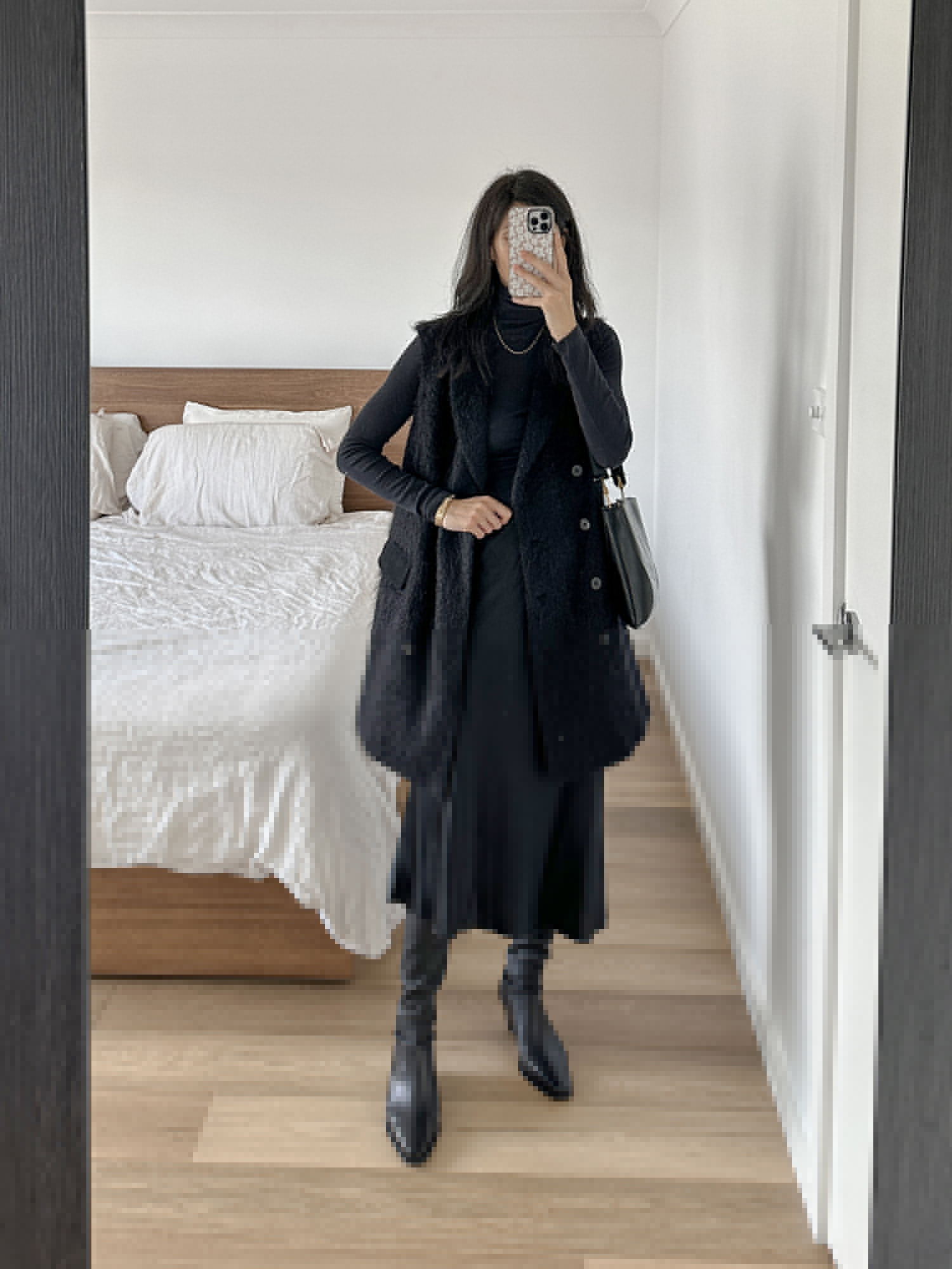 All black outfit wearing Quince black slip skirt and Arket knee high boots
